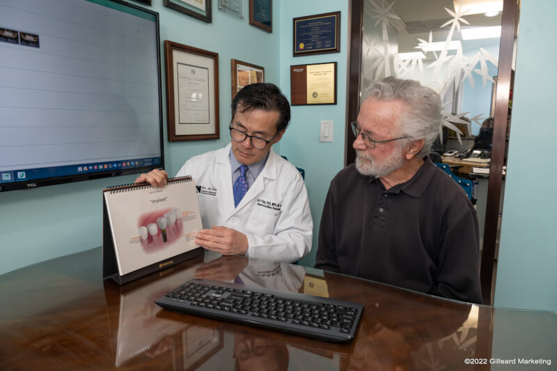 dentist showing patient implant diagram