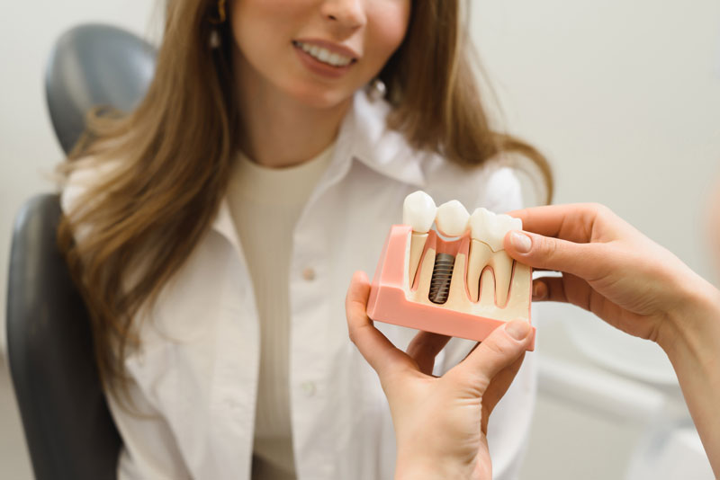 dental patient getting shown an implant model